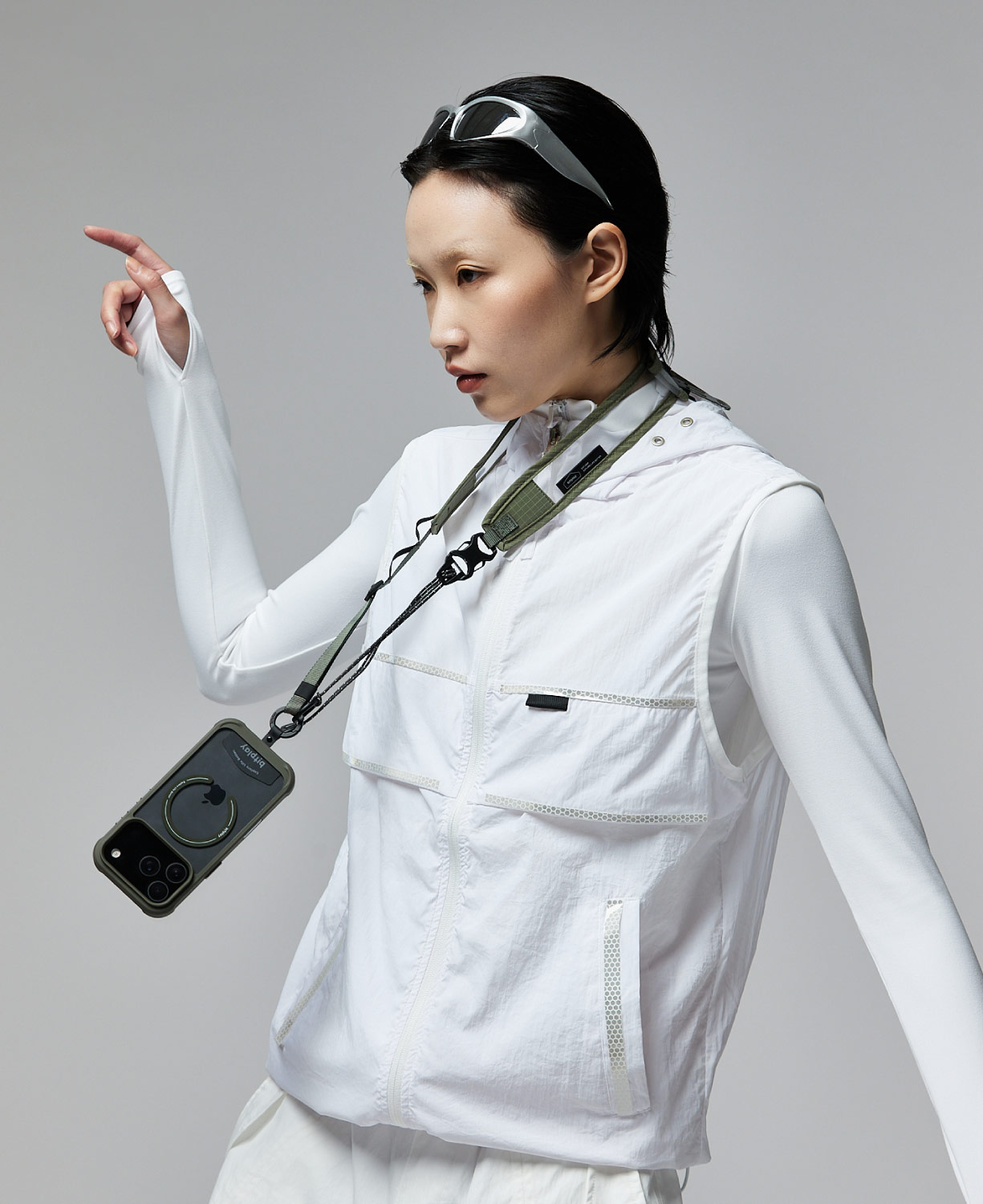bitplay Wanderメッシュストラップを付けたスマートフォンを首から下げる女性