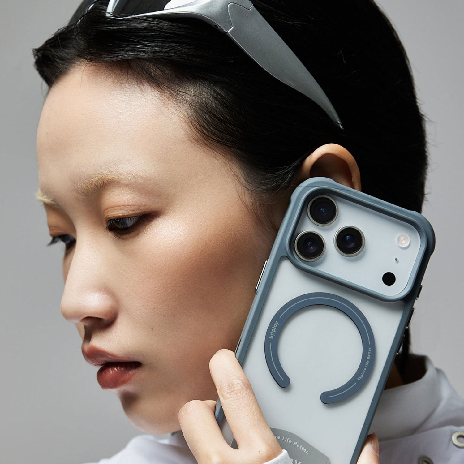 bitplay Wander Case for iPhone17シリーズのストーングレーが装着されているiPhoneを耳に当てる女性